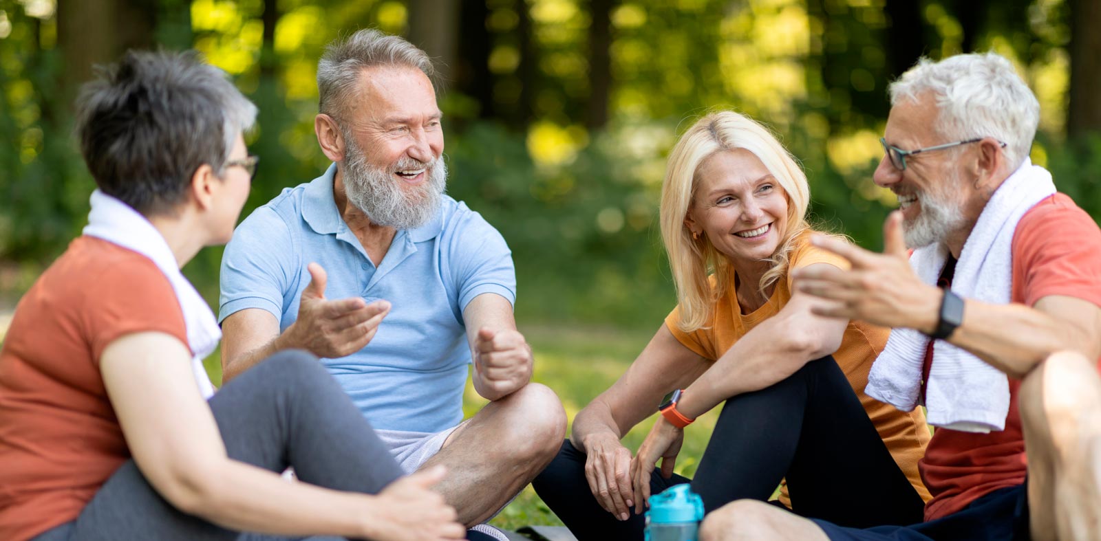 Gruppe älterer Freunde im Park, lachend und entspannt.